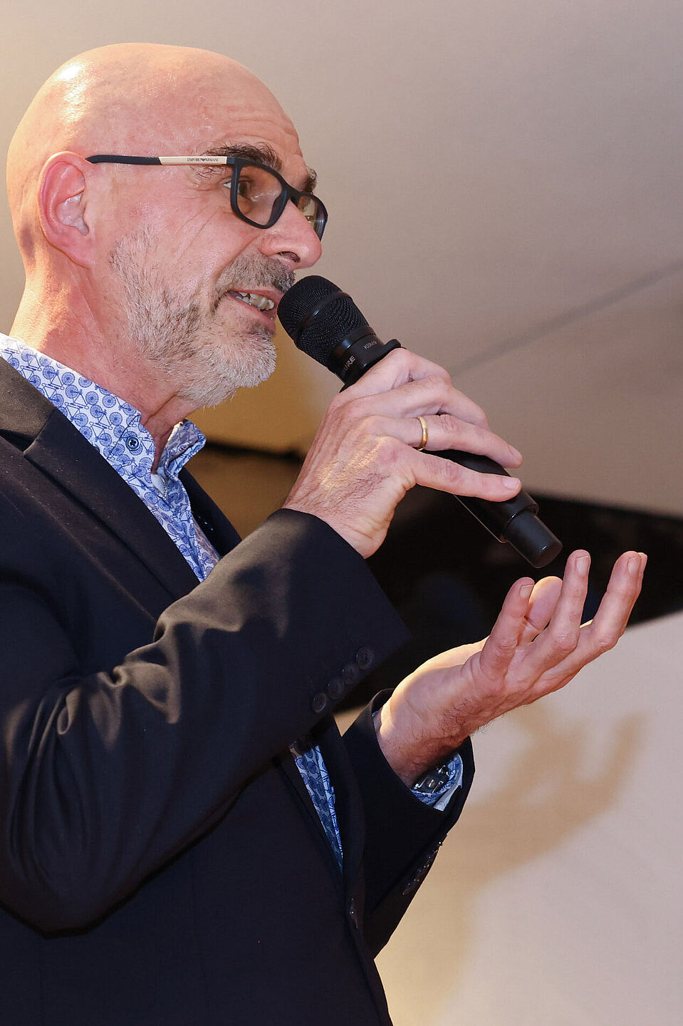 Axel Fell, ADFC NRW, Parlamentarischer Abend 2022 Der Landesvorsitzende des ADFC NRW, Axel Fell, spricht in ein Mikro. Er trägt ein gemustertes Hemd und ein schwarzes Sakko.